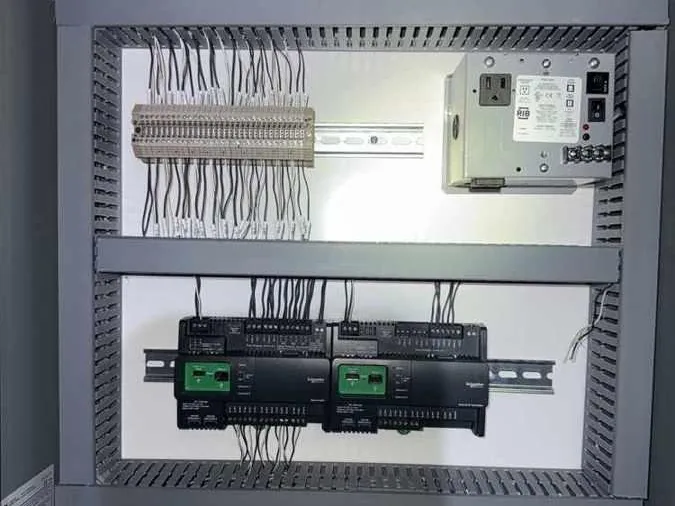 Control panel installed by PowerLogic: two controllers on DIN rail, a power supply and a labelled terminal strip